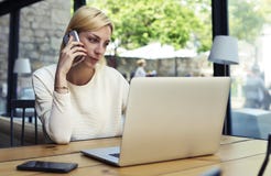 Female person talk on smartphone while looking to net-book screen stock photo Female person talk on smartphone while looking to net-book screen stock photo