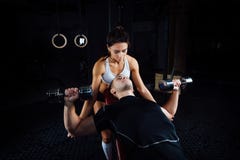 Female personal fitness instructor helping a young man at gym. stock photo Female personal fitness instructor helping a young man at gym. stock photo