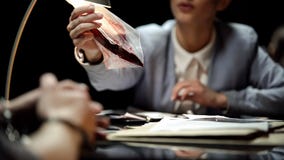 Female prosecutor showing knife with blood to suspect, waiting for confession royalty free stock photos Female prosecutor showing knife with blood to suspect, waiting for confession royalty free stock photos