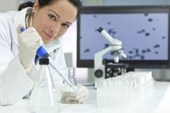Female Scientist With Pipette In Laboratory