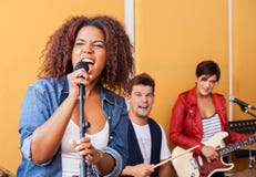 Female Singer Performing With Band Members In royalty free stock photo Female Singer Performing With Band Members In royalty free stock photo