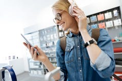 Female student trying out template headphones at electronics store