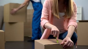Female student unpacking things in room, moving company worker carrying baggage royalty free stock image Female student unpacking things in room, moving company worker carrying baggage royalty free stock image