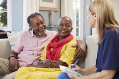 Female Support Worker Visits Senior Couple At Home stock photo Female Support Worker Visits Senior Couple At Home stock photo