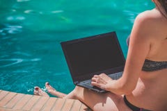 Female working on blank screen laptop at the swimming pool edge Royalty Free Stock Photo Female working on blank screen laptop at the swimming pool edge Royalty Free Stock Photo