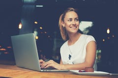 Femelle attirante avec le beau sourire se reposant avec le filet-livre portatif dans le café photographie stock libre de droits Femelle attirante avec le beau sourire se reposant avec le filet-livre portatif dans le café photographie stock libre de droits