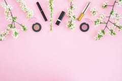 Feminine Desk With Cosmetic: Lipstick, Shadows, Mascara And White Spring Flowers On Pink Background. Flat Lay, Top View. Beauty Co Stock Photography Feminine Desk With Cosmetic: Lipstick, Shadows, Mascara And White Spring Flowers On Pink Background. Flat Lay, Top View. Beauty Co Stock Photography
