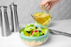 Femme ajoutant le vinaigre savoureux de pomme dans la salade Images stock Femme ajoutant le vinaigre savoureux de pomme dans la salade Images stock