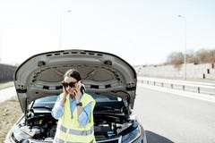 Femme appelle l'aide de route près de la voiture cassée sur la route photos stock Femme appelle l'aide de route près de la voiture cassée sur la route photos stock
