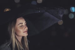 Femme appréciant la nuit pluvieuse Photo stock Femme appréciant la nuit pluvieuse Photo stock