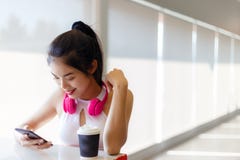 Femme assez asiatique de portrait : La fille attirante regarde le smartphone photographie stock Femme assez asiatique de portrait : La fille attirante regarde le smartphone photographie stock
