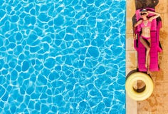 Femme attirante appréciant le bronzage par la piscine image libre de droits Femme attirante appréciant le bronzage par la piscine image libre de droits