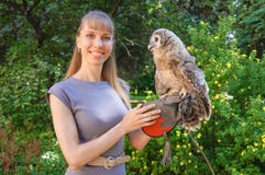 Femme attirante posant dans la robe grise avec un hibou sur son bras photo stock Femme attirante posant dans la robe grise avec un hibou sur son bras photo stock