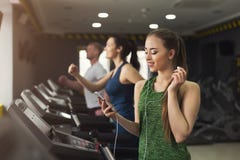 Femme attirante sur le tapis roulant dans le centre de fitness image libre de droits Femme attirante sur le tapis roulant dans le centre de fitness image libre de droits