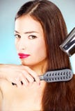 Femme avec le longs dessiccateur et peigne de coup de fixation de cheveu photo libre de droits Femme avec le longs dessiccateur et peigne de coup de fixation de cheveu photo libre de droits