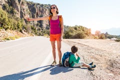 Femme avec un enfant faisant de l'auto-stop photos stock Femme avec un enfant faisant de l'auto-stop photos stock