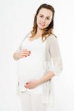 Femme blanche de sourire heureuse posant sur le fond blanc, en attendant la naissance d'un enfant photos stock Femme blanche de sourire heureuse posant sur le fond blanc, en attendant la naissance d'un enfant photos stock