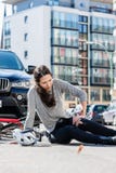 Femme blessée avec douleur sévère provoquée par entorse de genou après accident de bicyclette photo libre de droits Femme blessée avec douleur sévère provoquée par entorse de genou après accident de bicyclette photo libre de droits