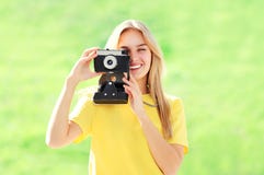 Femme blonde assez de sourire de portrait avec le rétro appareil-photo Image stock Femme blonde assez de sourire de portrait avec le rétro appareil-photo Image stock
