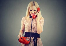 Femme blonde fâchée recevant la mauvaise nouvelle au téléphone photos stock Femme blonde fâchée recevant la mauvaise nouvelle au téléphone photos stock