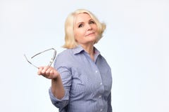 Femme caucasienne supérieure avec les cheveux blonds dans le sourire blanc et jaune de chandail photographie stock Femme caucasienne supérieure avec les cheveux blonds dans le sourire blanc et jaune de chandail photographie stock