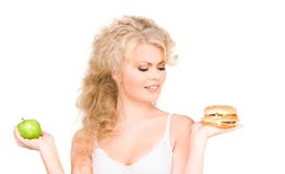 Femme choisissant entre l'hamburger et la pomme Photos stock
