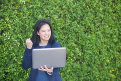 Femme d'affaires asiatique tenant le carnet d'ordinateur et montrant le pouce composant le geste correct photos libres de droits Femme d'affaires asiatique tenant le carnet d'ordinateur et montrant le pouce composant le geste correct photos libres de droits