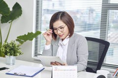 Femme d'affaires asiatique travaillant avec la tablette au bureau photos stock Femme d'affaires asiatique travaillant avec la tablette au bureau photos stock