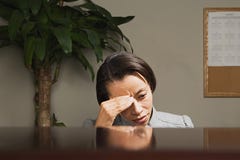 Femme d'affaires avec sa tête dans des ses mains Photo libre de droits Femme d'affaires avec sa tête dans des ses mains Photo libre de droits