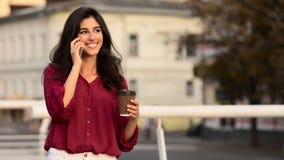 Femme d'affaires ayant la coupure, café potable et parlant au téléphone images stock Femme d'affaires ayant la coupure, café potable et parlant au téléphone images stock