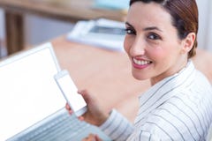 Femme d'affaires de brune souriant utilisant l'ordinateur portable et son mobile Photos libres de droits Femme d'affaires de brune souriant utilisant l'ordinateur portable et son mobile Photos libres de droits