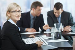 Femme d'affaires de sourire lors de la réunion Image stock Femme d'affaires de sourire lors de la réunion Image stock