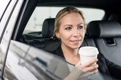 Femme d'affaires tenant la tasse de café se reposant dans la voiture images stock Femme d'affaires tenant la tasse de café se reposant dans la voiture images stock
