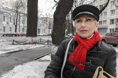 Femme d'une cinquantaine d'années calme élégante dans l'écharpe rouge photographie stock libre de droits Femme d'une cinquantaine d'années calme élégante dans l'écharpe rouge photographie stock libre de droits