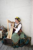 Femme dans la robe medival se reposant sur un banc jouant une harpe à l'OK 5 de Muskogee de festival de la Renaissance de l'Oklah image stock Femme dans la robe medival se reposant sur un banc jouant une harpe à l'OK 5 de Muskogee de festival de la Renaissance de l'Oklah image stock