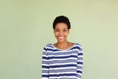 Femme de couleur heureuse dans la chemise rayée souriant par le fond vert Photographie stock libre de droits Femme de couleur heureuse dans la chemise rayée souriant par le fond vert Photographie stock libre de droits
