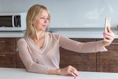 Femme de Moyen Âge prenant un selfie à la maison images libres de droits Femme de Moyen Âge prenant un selfie à la maison images libres de droits