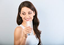 Femme de sourire heureuse positive avec la peau saine et les longs cheveux bouclés buvant l'eau pure et regardant en arrière sur photo stock Femme de sourire heureuse positive avec la peau saine et les longs cheveux bouclés buvant l'eau pure et regardant en arrière sur photo stock