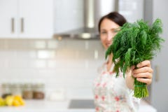 Femme de sourire tenant l'herbe organique fraîche d'aneth Femme préparant la nourriture délicieuse et saine dans la cuisine à la photos libres de droits Femme de sourire tenant l'herbe organique fraîche d'aneth Femme préparant la nourriture délicieuse et saine dans la cuisine à la photos libres de droits