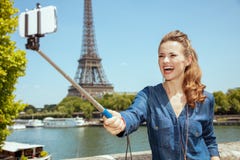 Femme de touristes soloe de sourire prenant le selfie utilisant le bâton de selfie photo stock Femme de touristes soloe de sourire prenant le selfie utilisant le bâton de selfie photo stock