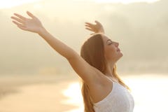 Femme décontractée respirant l'air frais soulevant des bras au lever de soleil image libre de droits Femme décontractée respirant l'air frais soulevant des bras au lever de soleil image libre de droits