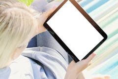 Femme détendant dans un hamac utilisant un comprimé numérique photos libres de droits Femme détendant dans un hamac utilisant un comprimé numérique photos libres de droits