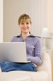 Femme détendant sur le sofa dans la salle de séjour images stock Femme détendant sur le sofa dans la salle de séjour images stock