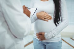 Femme enceinte agissant l'un sur l'autre avec le docteur Images stock Femme enceinte agissant l'un sur l'autre avec le docteur Images stock