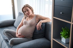 Femme enceinte gaie détendant à la maison images libres de droits Femme enceinte gaie détendant à la maison images libres de droits