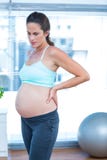 Femme enceinte réfléchie dans la classe de yoga photographie stock libre de droits Femme enceinte réfléchie dans la classe de yoga photographie stock libre de droits