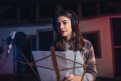 Femme enregistrant une chanson dans le studio de musique photo libre de droits Femme enregistrant une chanson dans le studio de musique photo libre de droits