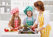 Femme et enfants lavant des légumes dans la cuisine photographie stock Femme et enfants lavant des légumes dans la cuisine photographie stock