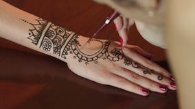 Femme faisant le henné tatouer en main, plan rapproché banque de vidéos Femme faisant le henné tatouer en main, plan rapproché banque de vidéos
