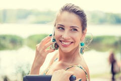 Femme heureuse souriant et marchant dans la rue parlant sur un smartphone photographie stock Femme heureuse souriant et marchant dans la rue parlant sur un smartphone photographie stock